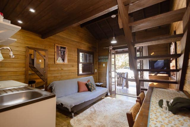 Interior de chalé em madeira, com sala e cozinha integradas